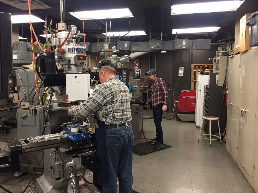 Two machinists working with equipment