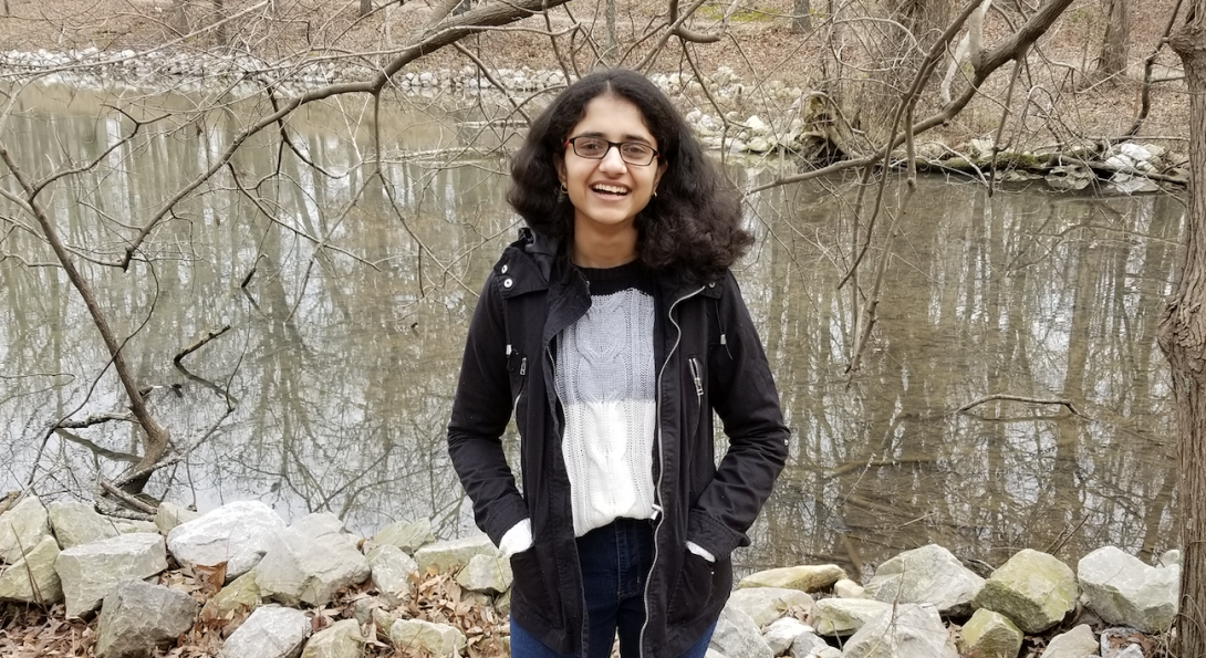 Lopa Bhatt standing in a wooded area with a big smile on her face.