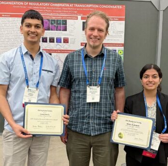 picture of faculty member Jan Spille and two graduate students holding certificates in front of research poster 